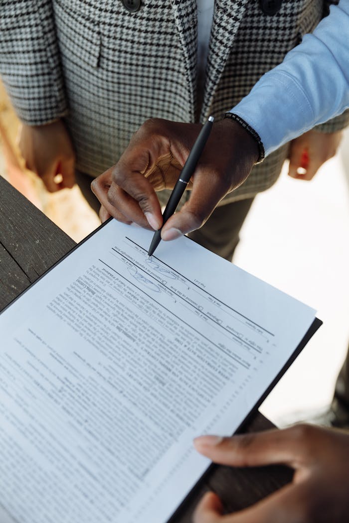 Mastering the First Impression: Your intriguing post title goes here Detailed view of a person signing a business contract with a pen, emphasizing agreement and ownership.